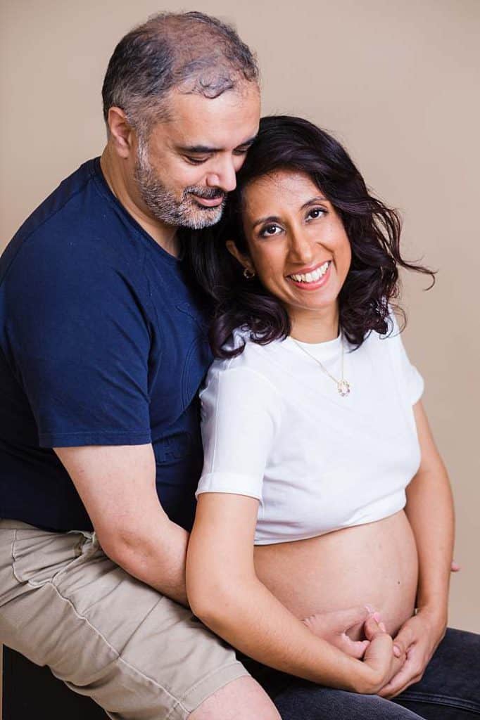 husband-cuddling-pregnant-wife-belly-white-cropped-t-shirt-jeans-maternity-couple-portrait