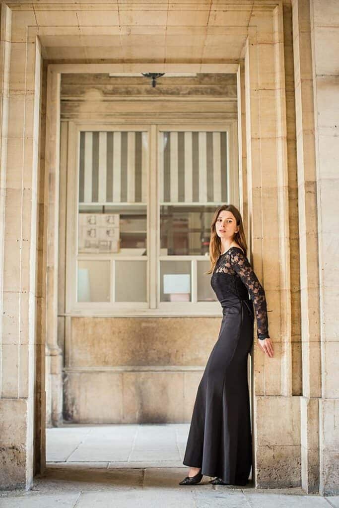 romantic-portrait-photography-in-paris-at-louve-royal-palace-girl-in-elegant-black-dress-leaning-against-door-frame