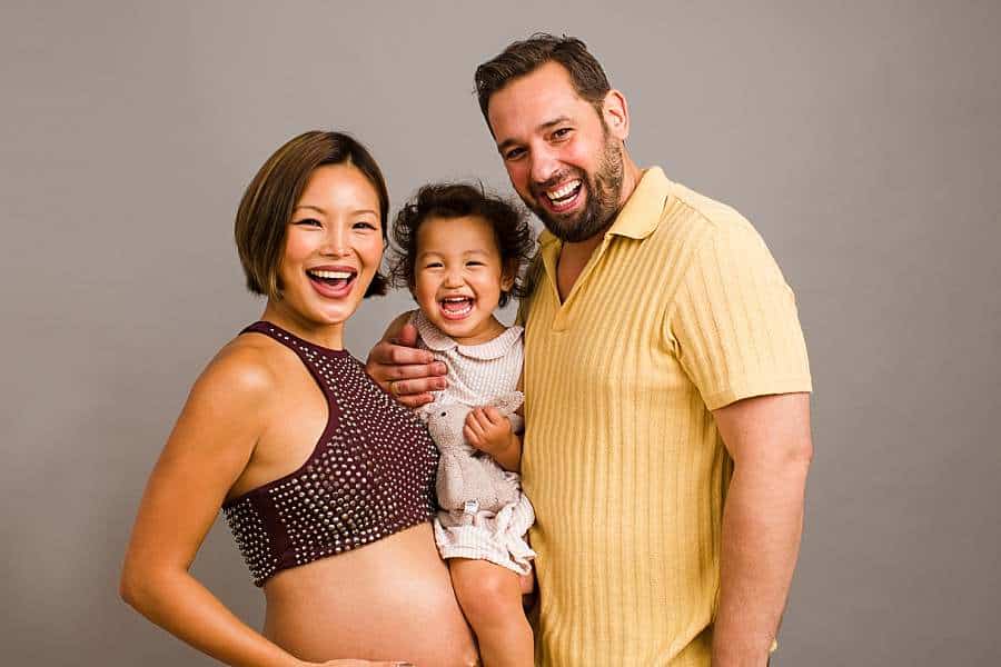 family-pregnancy-photoshoot-expecting-mother-and-father-cudding-toddler